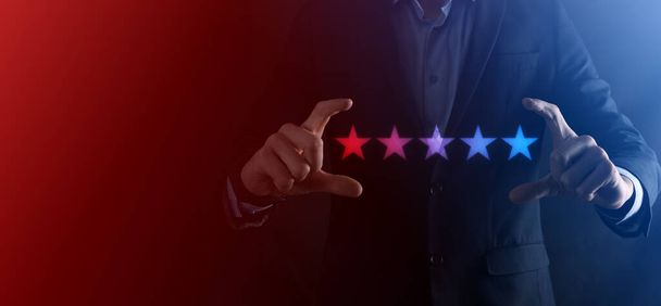 Man hand tonen op vijf sterren uitstekende rating.pointing vijf sterren symbool om de rating van het bedrijf te verhogen.Review, verhoging van de rating of ranking, evaluatie en classificatie concept. - Foto, afbeelding