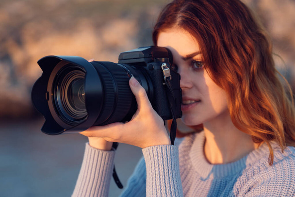 mooie roodharige vrouw met een camera op de natuur. Hoge kwaliteit foto - Foto, afbeelding