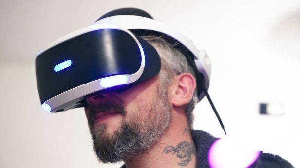 Un uomo che indossa un auricolare di realtà virtuale. - Foto, immagini
