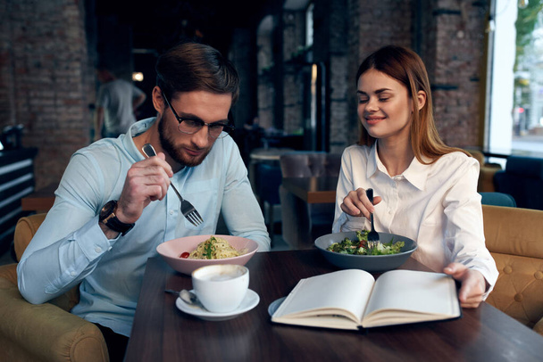 деловой мужчина и женщина завтракают в кафе, общаются коллеги по работе - Фото, изображение