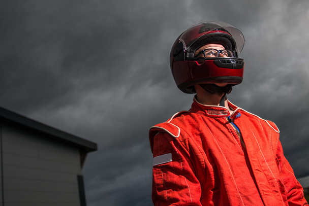 Motorista de carro de corrida usando capacete protetor
 - Foto, Imagem