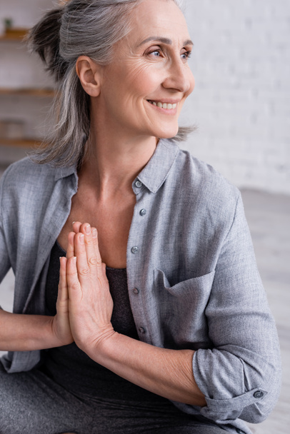 šťastný zralý žena s šedivými vlasy a modlící se ruce  - Fotografie, Obrázek