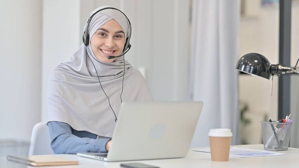 Laptoplu Genç Arap Kadın Kulaklıkla Gülümsüyor  - Fotoğraf, Görsel