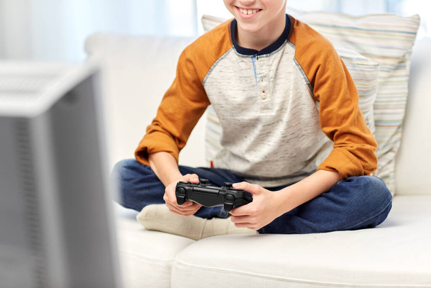 happy boy with gamepad playing video game at home - Foto, imagen