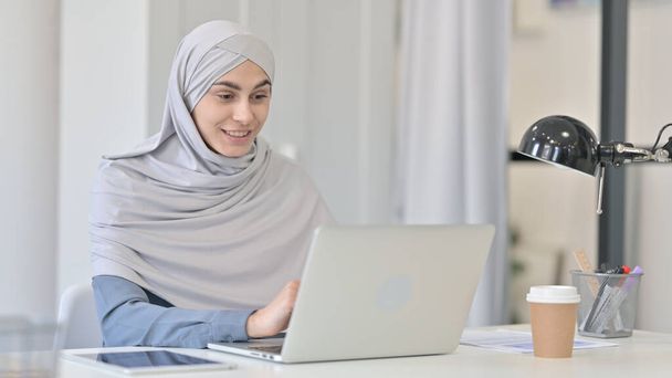 Mujer árabe joven hablando en video llamada en el ordenador portátil  - Foto, imagen