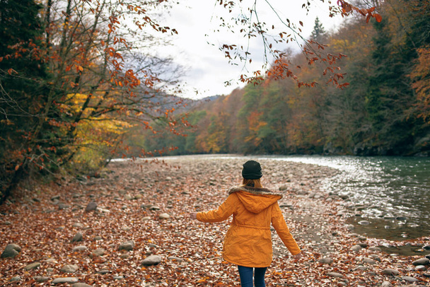 mujer excursionista cerca del río en las montañas viaje de otoño. Foto de alta calidad - Foto, Imagen
