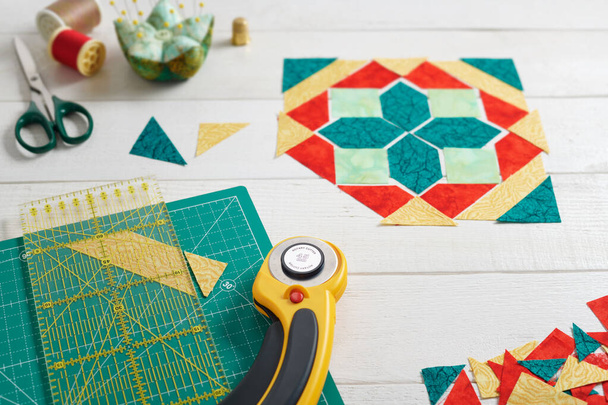 Pieces of fabric laying out in the shape of a patchwork block, sewing and quilting accessories. Traditional quilting. - Foto, Imagem