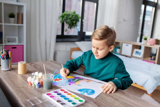 boy with colors and brush drawing picture at home - Фото, зображення