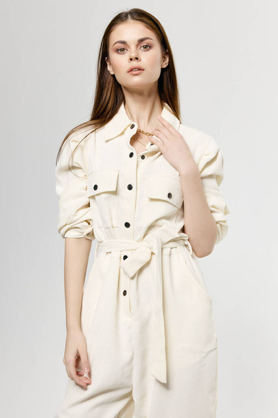 Schöne Dame im weißen Overall auf einem hellen Hintergrund modische Kleidung Stil-Modell - Foto, Bild