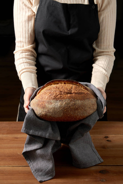 female baker with homemade bread at bakery - Fotó, kép