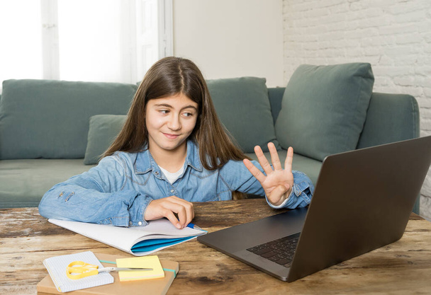 Happy Teen girl on laptop studying online in virtual remote class on the internet at home as high school remain closed due to latest coronavirus lockdown. COVID-19, education, children, E- learning. - Foto, Bild