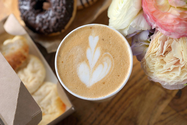 Cappuccino en una taza de papel y comida variada - Foto, imagen