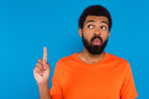 shocked african american man pointing up isolated on blue - Foto, Imagem