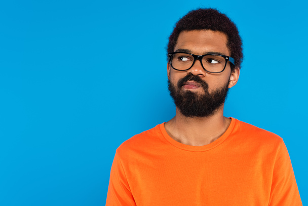 pochybný africký Američan v brýlích izolovaných na modré - Fotografie, Obrázek