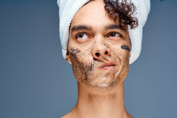 chico con una toalla en la cabeza cosméticos cuidado de la piel de cerca - Foto, Imagen