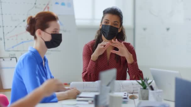オフィスでブレインストーミングをするマスクの人々。テーブルボードルームに座っている保護チーム.  - 映像、動画