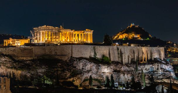 Obraz Akropolu Aten, szczególnie Partenonu, widziany z wzgórza Filopappou, w nocy. - Zdjęcie, obraz