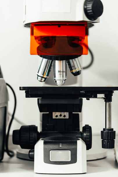microscopio con lentes de aumento en el laboratorio químico. Aparato científico para analizar partículas, virus, ADN... - Foto, Imagen