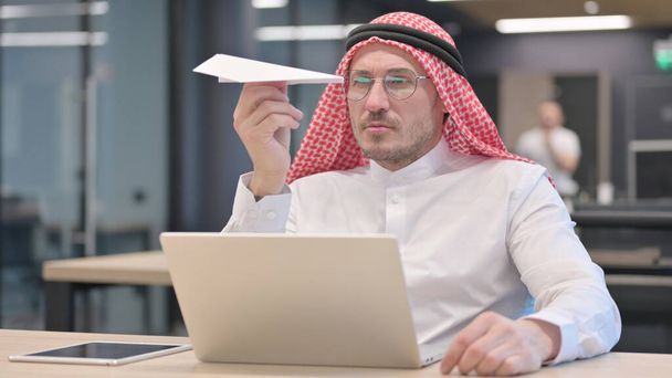 Plano de papel volador del hombre árabe de mediana edad pensativo  - Foto, Imagen