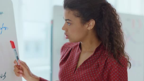 Femme afro regardant tableau blanc à l'intérieur. Coach d'affaires pointant la main tableau à feuilles mobiles - Séquence, vidéo