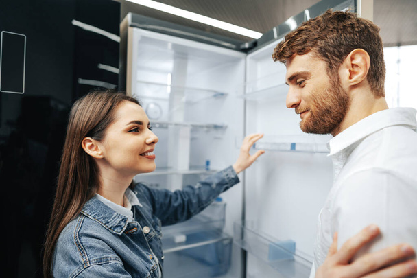 Young couple selecting new refrigerator in household appliance store - Zdjęcie, obraz