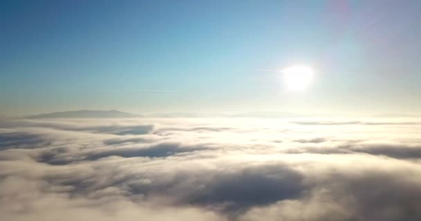 Vzdušný záběr vznešeného východu slunce v horách. Údolí mezi horami je pokryto mlhou a je ozářeno teplými paprsky vycházejícího slunce. Hory pokryté přírodním lesem. - Záběry, video