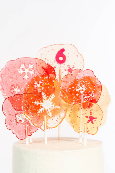Close up of large clear pink and white lollipops with snowflakes and sprinkles. - Photo, Image