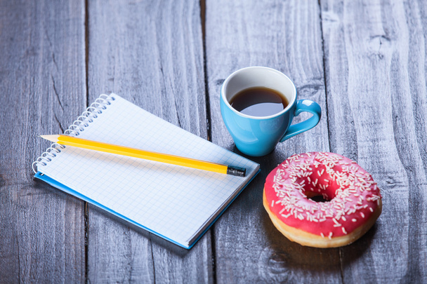 φλιτζάνι καφέ με το σημειωματάριο και ντόνατ. - Φωτογραφία, εικόνα