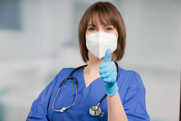 icu Krankenschwester oder Arzt geschützt durch medizinische Gesichtsmaske und medizinische Handschuhe zeigt Daumen nach oben - Foto, Bild