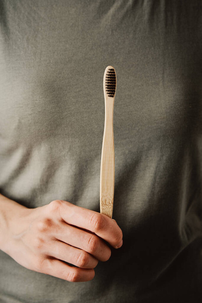 Woman hold bamboo toothbrush, close up - Foto, Imagem