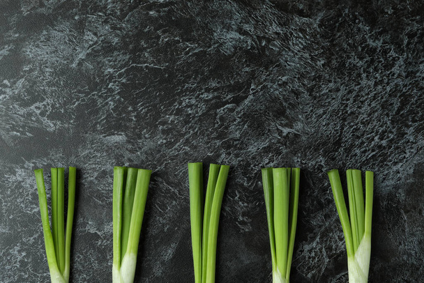 Fresh green onion on black smokey background - Foto, immagini