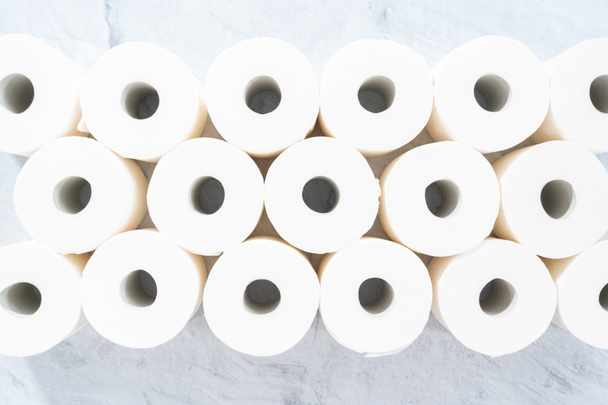 Flat lay. New white toilet paper rolls on a gray background. - Foto, afbeelding