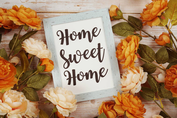 Home Sweet Home typography text with flower decoation on wooden background - Photo, Image