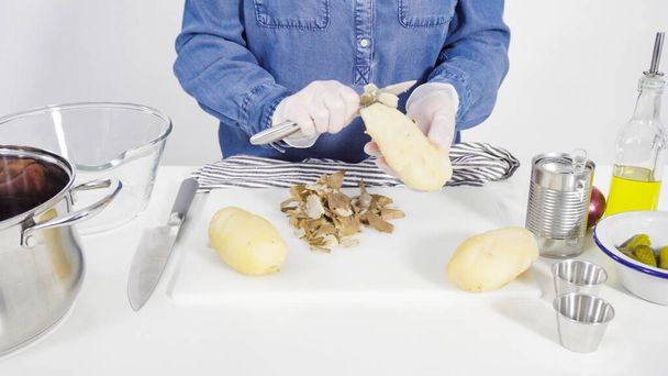 Krok za krokem. Sekání sušenek zelenina na bílém řezacím prkně na salát. - Fotografie, Obrázek
