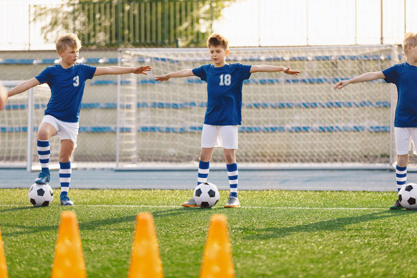 Futbol Kulübü Çocukları Eğitimle Oynuyor. Bir grup okul çocuğu eğitim biriminde. Futbol antrenmanı sırasında çocuklar esneme hareketleri - Fotoğraf, Görsel
