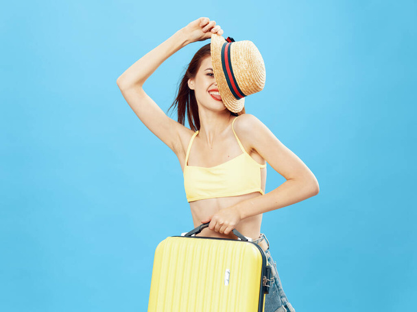 cheerful woman with luggage on blue  background. High quality photo - Фото, зображення