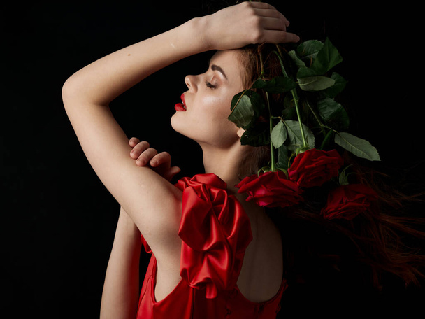 žena v červených šatech květiny půvab luxus tmavé pozadí - Fotografie, Obrázek