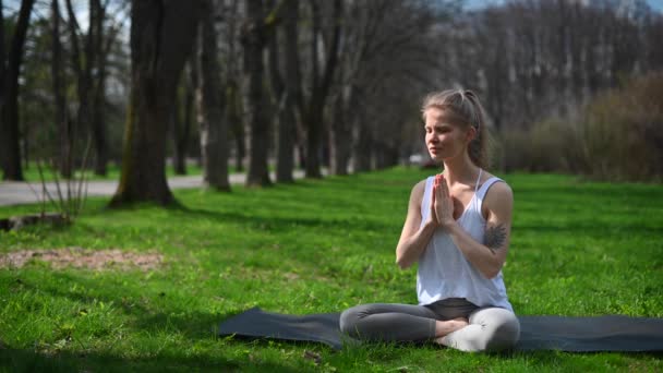 Йога и медитация на открытом воздухе. Девушка в парке - Кадры, видео