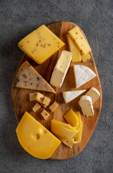 Cheese platter on wooden board. Cheese background. Closeup. - Fotó, kép