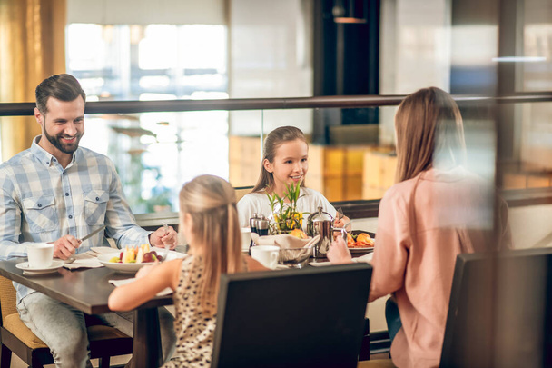 Happy family sitting at the table in the restaurant - 写真・画像