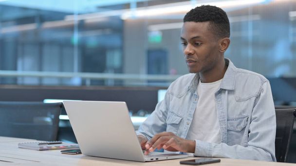 Uomo africano che lavora sul computer portatile in ufficio  - Foto, immagini