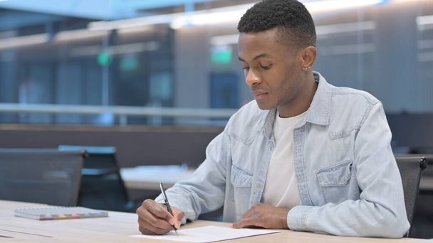 Homme africain pensif écrivant sur papier, pensant  - Photo, image