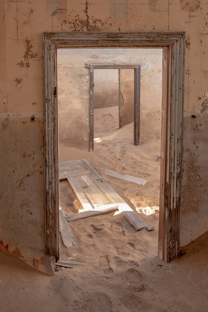 заброшенный интерьер здания с полом, покрытым песками пустыни из города Колманскоп в Намиби - Фото, изображение