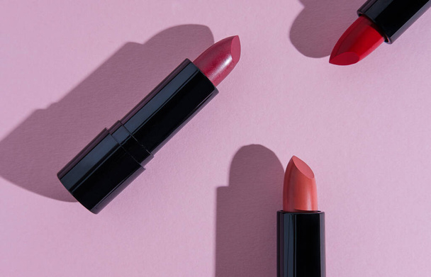 Set of lipsticks on light pink background. General cosmetic products illustration. - Foto, imagen