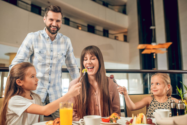 Smiling family sitting at the table and having fun - Φωτογραφία, εικόνα