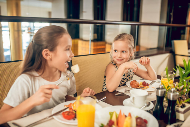 Cute siblings sitting at the table and having breakfast - Fotografie, Obrázek
