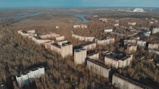 Blick auf die Geisterstadt Pripjat mit dem Kernkraftwerk Tschernobyl und dem Sarkophag im Hintergrund. 35 Jahre nach Katastrophe und Evakuierung. Reisen während der Pandemie von Covid-19 - Filmmaterial, Video