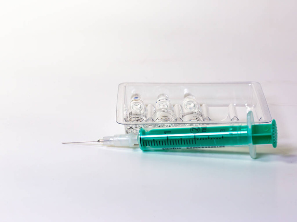a syringe and ampules on white background (copy space) - Фото, зображення