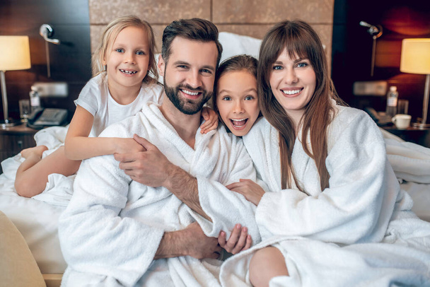 Family in white robes smiling and looking wonderful - Fotografie, Obrázek