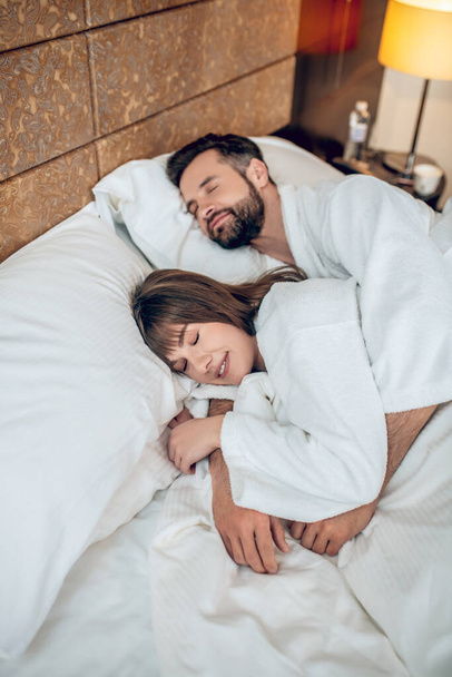 Couple in white robes sleeping and looking peaceful - Valokuva, kuva